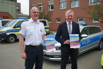 Auf dem Bild sind Polizeiinspektionsleiter Stefan Sengel und Polizeipräsident Thomas Ring mit dem Sicherheitsbericht in den Händen zu sehen.